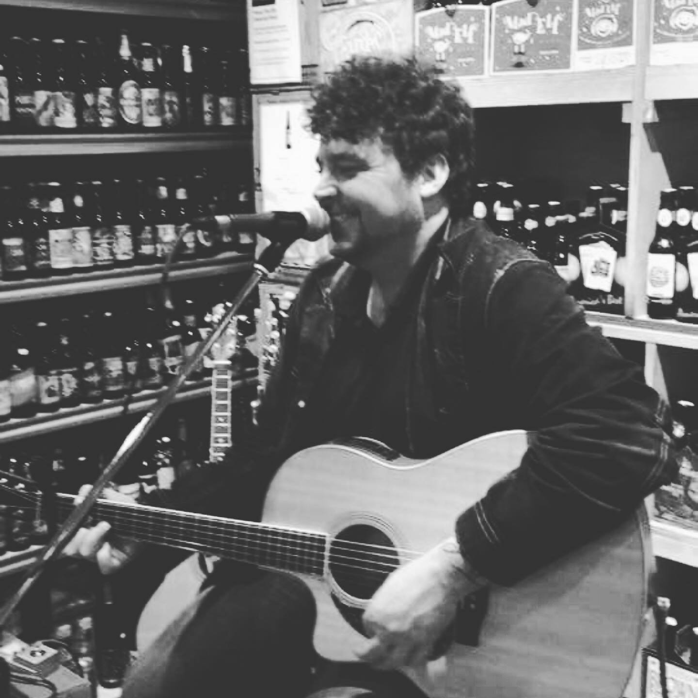 A man playing a guitar at a local brewery